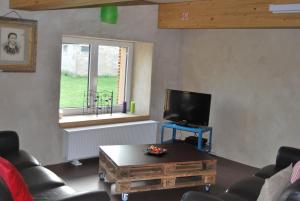 een woonkamer met een tv en een salontafel bij Gite MontBleu - 2 holiday houses - La Laiterie & La Grange in Sprimont