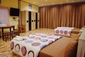 a large room with two beds and a table at Ruanmai Style Resort 2 in Ban Nong Nam Khan