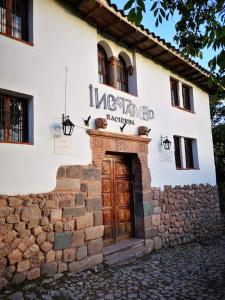 un edificio con una puerta con un cartel. en Inka Tambo Hacienda, en Cusco