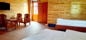 Cette chambre comprend deux lits, une table et un bureau. dans l'établissement Sa House Bac Ha, à Bắc Hà