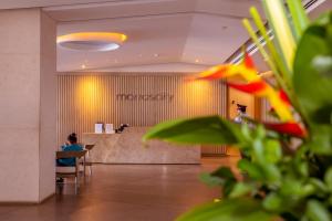 a person sitting at a table in a lobby at 41st Fl Beach Condo in Bocagrande in Cartagena de Indias