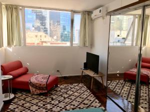 布宜诺斯艾利斯Bright, open view studio in Retiro的客厅设有红色的沙发和窗户。