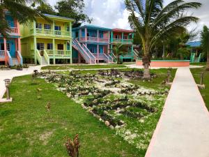 a garden in front of a row of colorful houses at Sunshine View Hotel and Restaurant in Corozal
