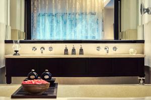 a bathroom with a sink with a bowl of flowers at Anantara Bophut Koh Samui Resort in Bophut