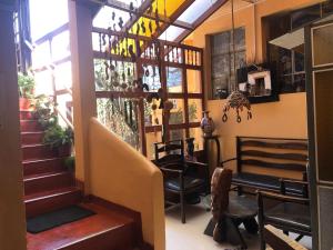 a living room with a staircase and a chair at Hospedaje Turistico Recoleta in Cusco