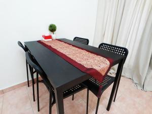 una mesa negra con un mantel rojo. en JJ Melaka Holiday home, en Melaka
