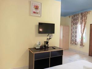 a hotel room with a tv on the wall at Sunshine View Hotel and Restaurant in Corozal