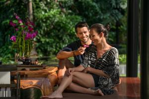 a man and a woman sitting next to a table at Anantara Bophut Koh Samui Resort in Bophut