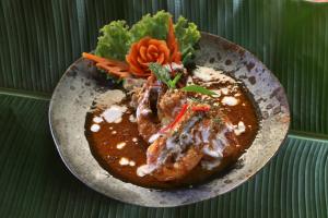 a plate of food with meat and vegetables on a table at Anantara Bophut Koh Samui Resort in Bophut