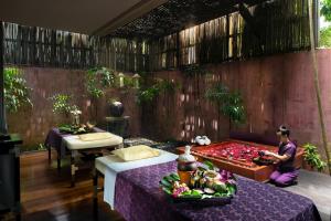 a woman sitting in a room with two beds at Anantara Bophut Koh Samui Resort in Bophut