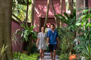 a man and a woman walking through a garden at Anantara Bophut Koh Samui Resort in Bophut