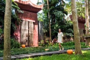 a woman in a white dress walking in front of a building at Anantara Bophut Koh Samui Resort in Bophut