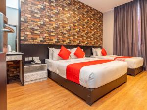 a bedroom with two beds and a brick wall at De Sweet Boutique Hotel in Johor Bahru