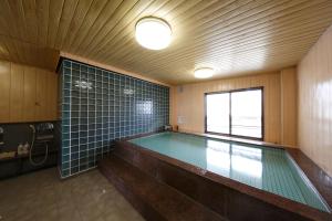 ein Swimmingpool in einem Raum mit einem großen Fenster in der Unterkunft Masunoi in Mie