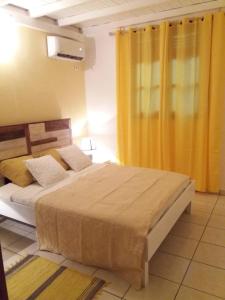 ein Schlafzimmer mit 2 Betten und einem gelben Vorhang in der Unterkunft Villa Ponm Kann'L in Deshaies