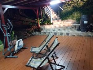 zwei leere Stühle, die nachts auf einer Terrasse sitzen in der Unterkunft Villa Ponm Kann'L in Deshaies