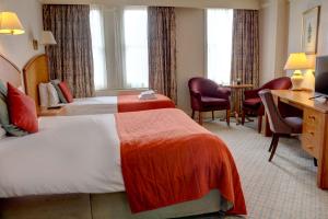 um quarto de hotel com duas camas e uma secretária em Crown & Mitre Hotel em Carlisle