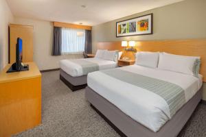 a hotel room with two beds and a flat screen tv at Hotel Nexus; BW Signature Collection in Seattle +13 photos