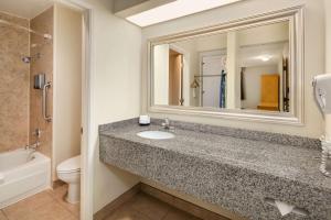 a bathroom with a sink and a toilet and a mirror at Hotel Nexus; BW Signature Collection in Seattle
