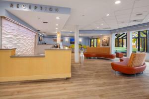 a lobby of a hospital with orange chairs and a reception at Hotel Nexus; BW Signature Collection in Seattle