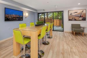 a dining room with a table and green chairs at Hotel Nexus; BW Signature Collection in Seattle