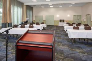 a conference room with tables and a podium with microphones at Hotel Nexus; BW Signature Collection in Seattle