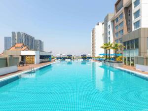 a large swimming pool in a city with tall buildings at Novotel Yangon Max in Yangon