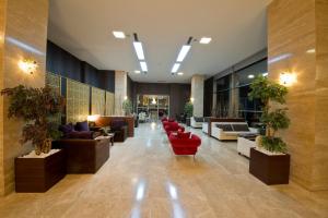 a lobby with couches and plants in a building at North Point Hotel in Denizli