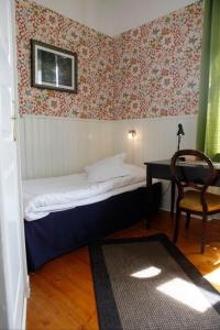 
a room with a bed, a chair, and a window at Hotell Edgar & Lilla Kök in Sölvesborg
