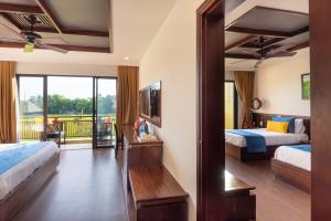 a hotel room with two beds and a balcony at Eden Hoi An Villas in Hoi An +47 photos