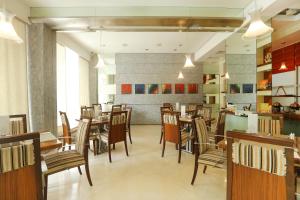 a dining room with tables and chairs in a restaurant at Regency Hotel Malabar Hill in Mumbai