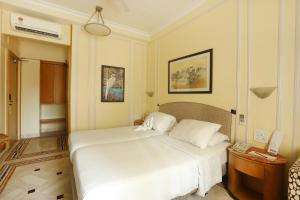 Regency Hotel Malabar Hill tesisinde bir odada yatak veya yataklar