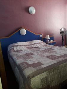 a bedroom with a bed with a blue head board at Hôtel des Jacobines in Chalon-sur-Saône