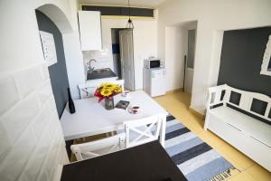 Il comprend une petite cuisine avec une table et des chaises blanches. dans l'établissement Ultra central apartment, à Cluj-Napoca