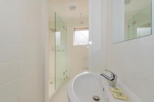 un bagno bianco con vasca e doccia di 4 Bedroom House - Hobart CBD - Free Parking - Free WIFI a Hobart Altre 17 foto