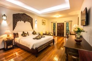 a bedroom with a king sized bed and a table at Pingdoi Hualin Boutique Hotel in Chiang Mai +69 photos