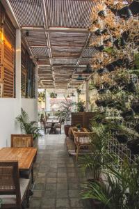a patio with benches and tables and plants at Adhisthana Hotel Yogyakarta in Yogyakarta