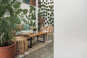 a patio with plants and a table and chairs at Adhisthana Hotel Yogyakarta in Yogyakarta