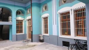 un edificio azul con ventanas y una bicicleta estacionada fuera en A piece of history in Moscovitz Palace, en Oradea