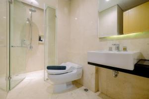 Un baño con inodoro, lavabo y ducha. en Spacious Studio Room at Capitol Suites Apartment By Travelio, en Yakarta 5 fotos más