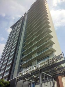 un edificio alto con un cartel en él en Spacious Studio Room at Capitol Suites Apartment By Travelio, en Yakarta