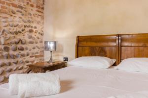 a bedroom with a bed with a wooden headboard at Spazio Seicentesco in Verona