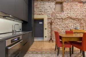 a kitchen with a wooden table and red chairs at Spazio Seicentesco in Verona