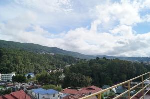 a view of a city with mountains and trees at Woodland Hill Stay in Shillong