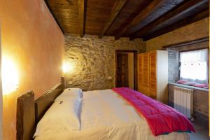 a bedroom with a bed in a stone wall at Rifugio del Firenze Ninfa in Sestola