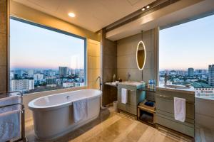 a bathroom with a tub and a large window at Hotel Nikko Saigon in Ho Chi Minh City