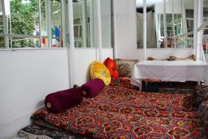 Habitación con alfombra y almohadas en el suelo en Anvar's Guests, en Tashkent