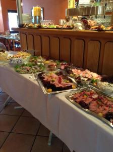 una línea de buffet con muchos tipos diferentes de comida en Gästehaus Oh-La-La en Wilster