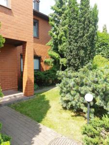 un edificio de ladrillo con un arbusto delante de él en Ochota Forest Guest House, en Varsovia