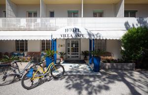 Dos bicicletas estacionadas frente a una villa de hotel en Hotel Villa Aspe, en Bibione